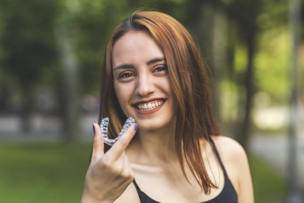 woman holding invisalign | invisalign clear braces dentist 94087