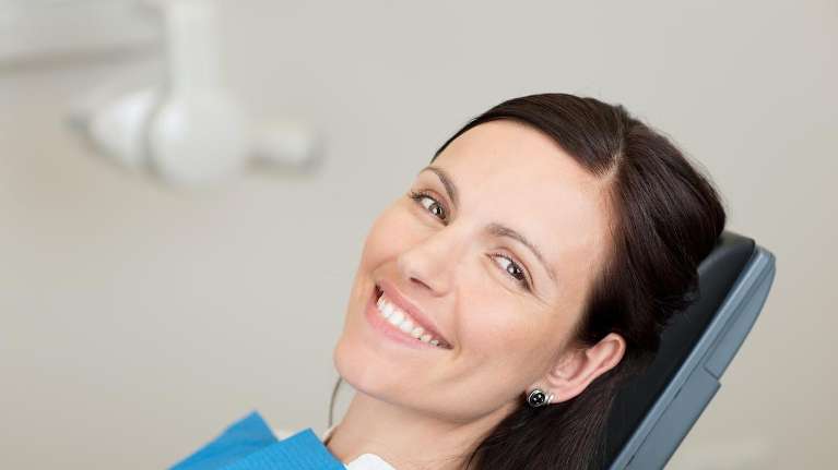 woman sitting in dentist exam chair smiling | dentist sunnyvale ca