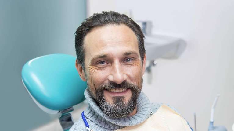 man sitting in dentist exam chair | dental implants sunnyvale