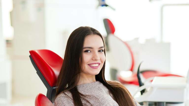 woman sitting in dentist chair | dental crowns sunnyvale